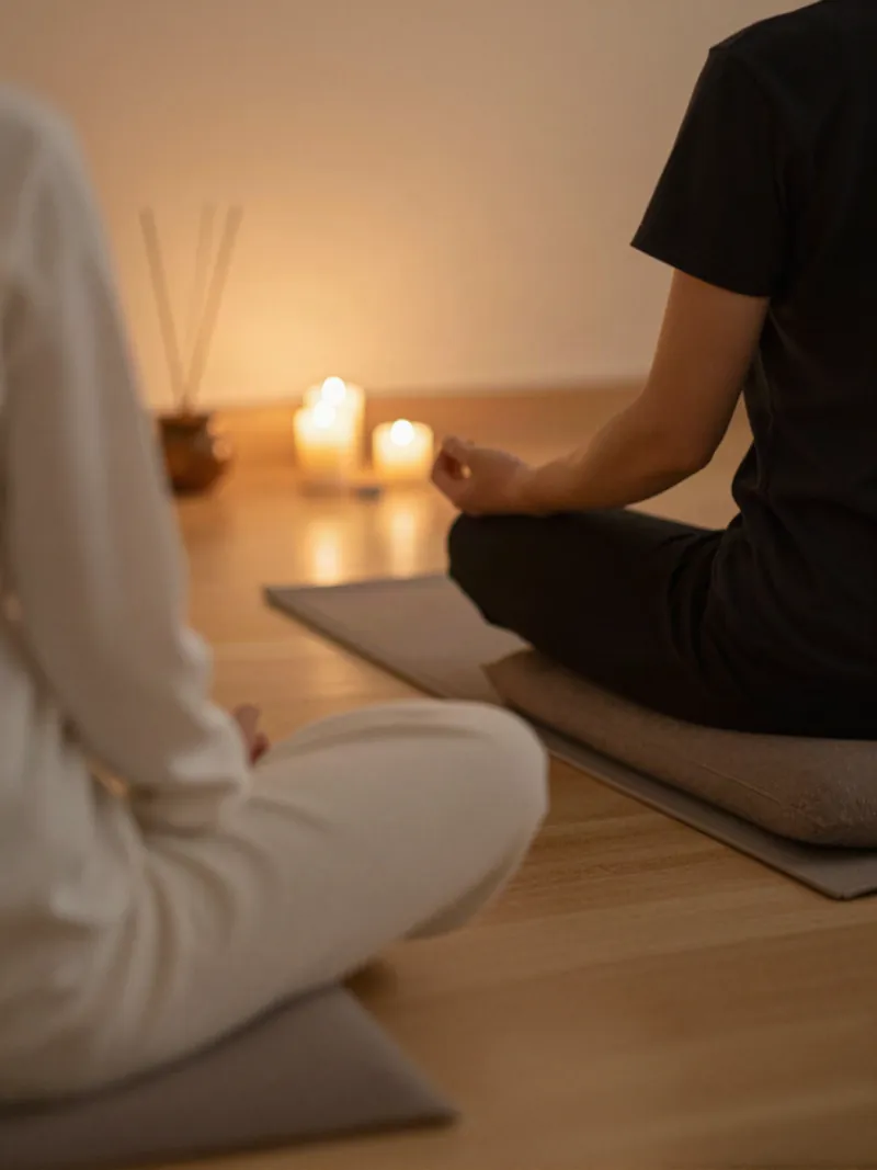 Persona meditando de espaldas entre velas